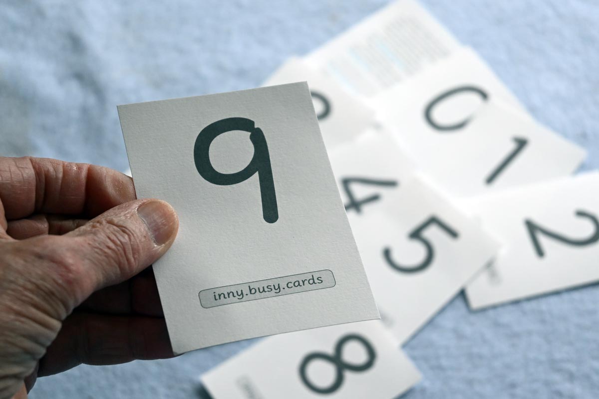 The digit nine, printed on thick cartridge paer, held in the hand to show scale